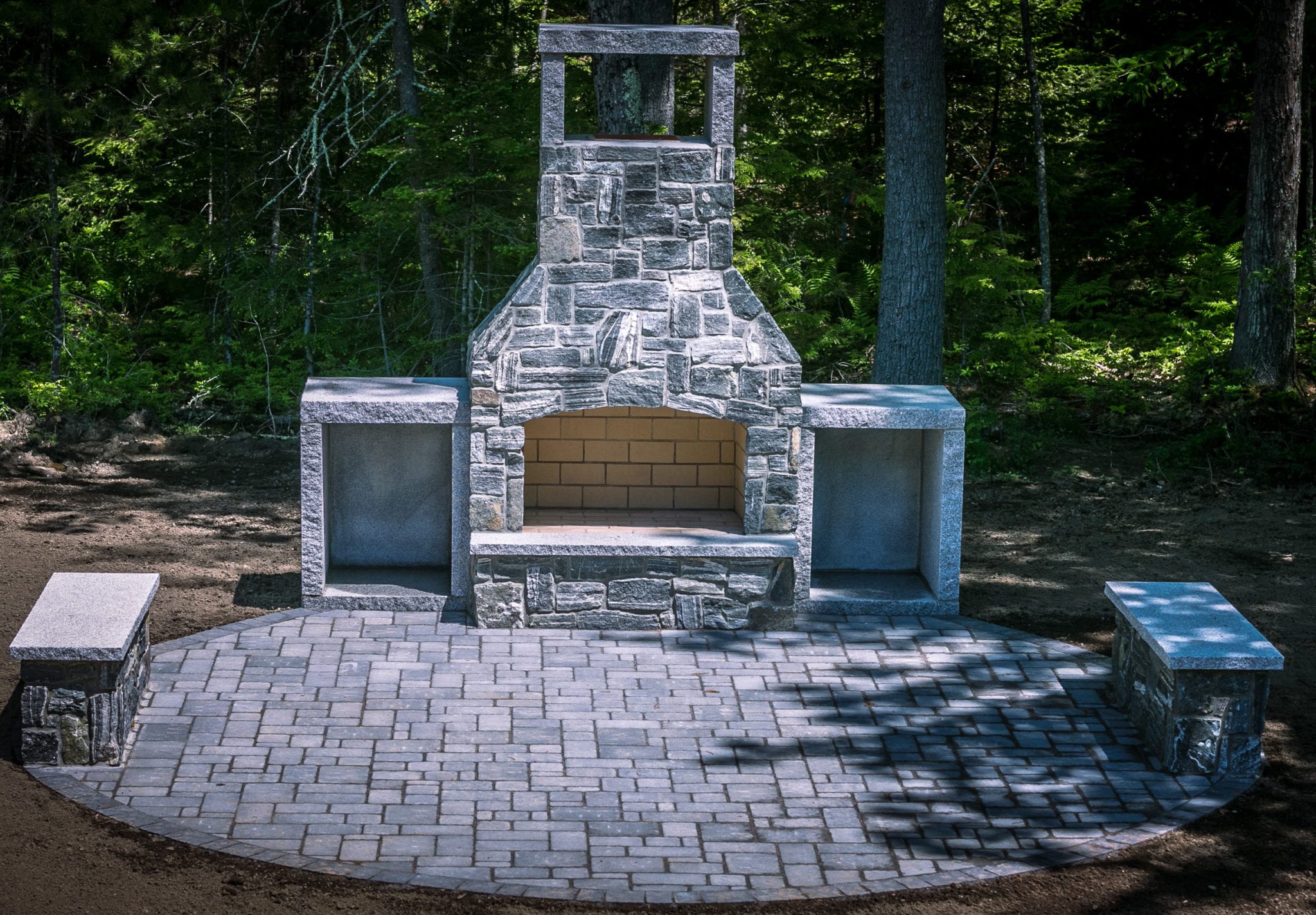 Outdoor Stone Fireplace with granite patio and firewood boxes