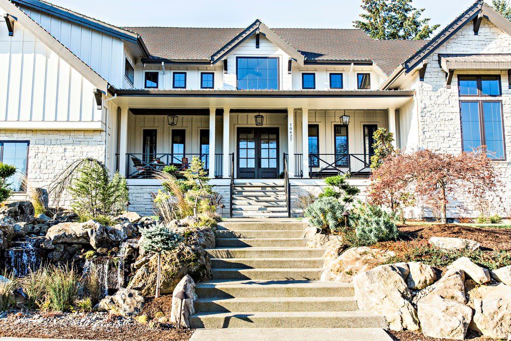 A white home with landscape features in the front