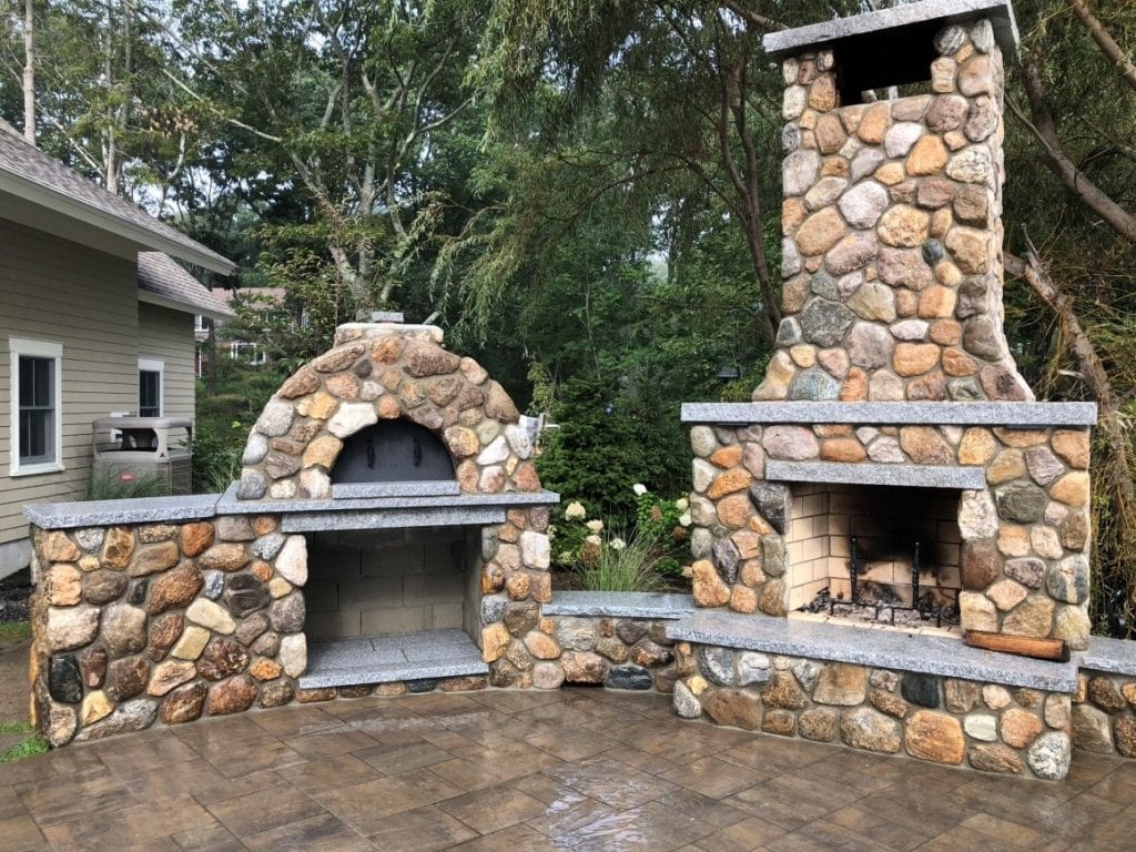 A beautiful stone fireplace built in an outdoor space