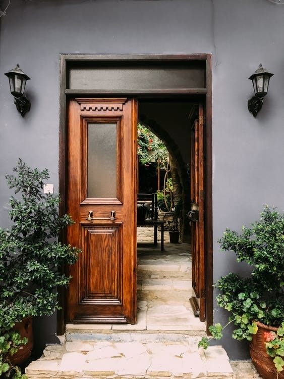 House entrance with brown front door and planters.