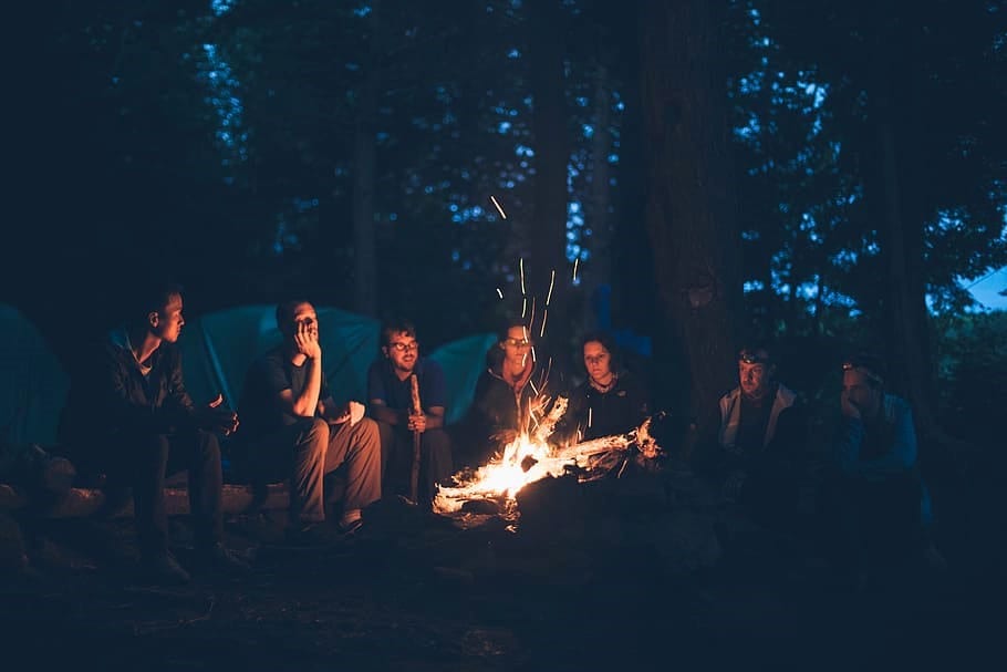 Group of friends sitting around a fire pit in the backyard.