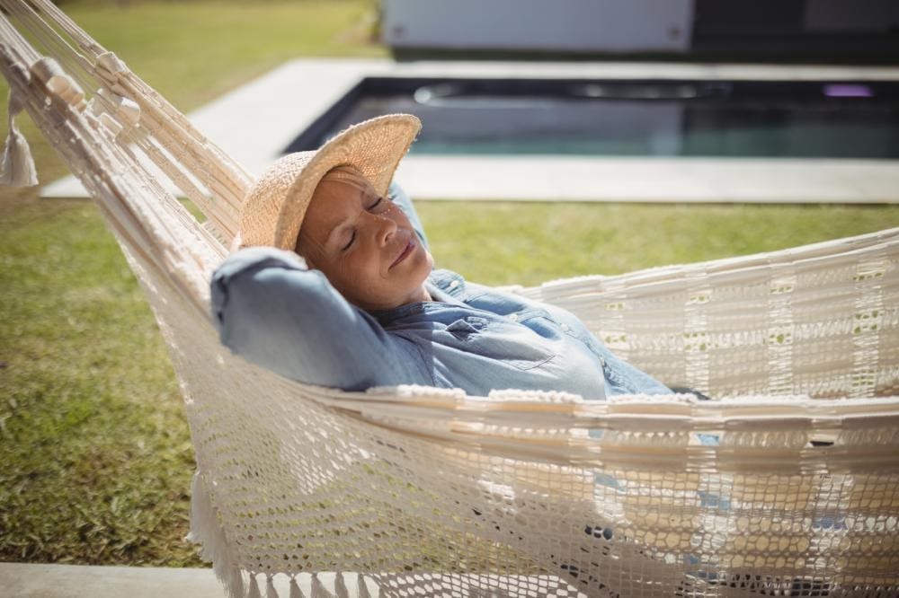 woman relaxing on a hammock in her backyard