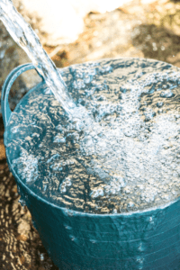 cleaning bucket filled with soap and water to wash stone wall