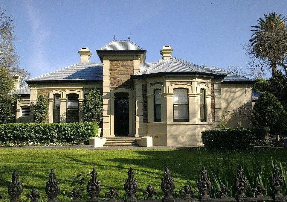 A beautiful mansion home with a stone wall