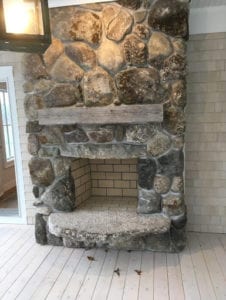 A living room with a magnificent stone wall fireplace.