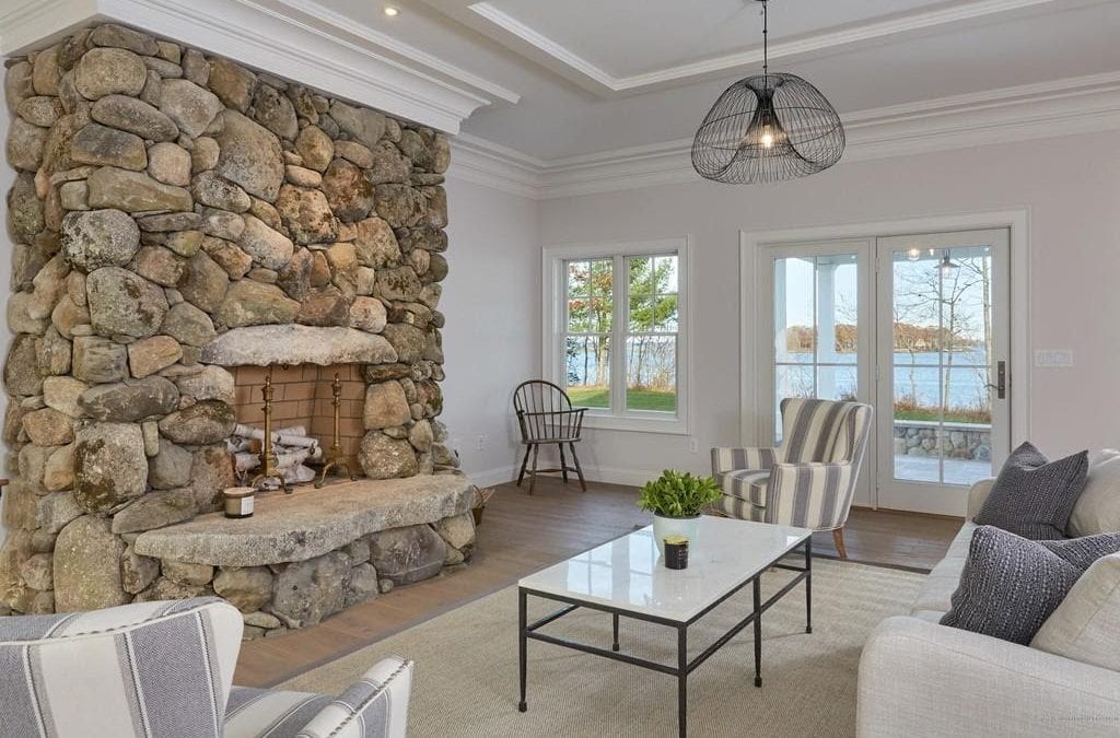 A living room with a stone wall fireplace.