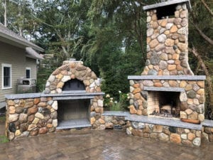 A pizza oven made of stone in the backyard.