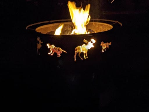 A round fire pit in a backyard.