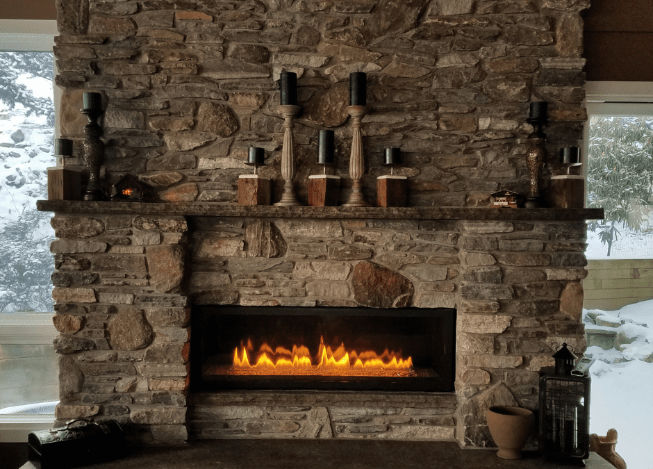 A stone fireplace decorated for winter