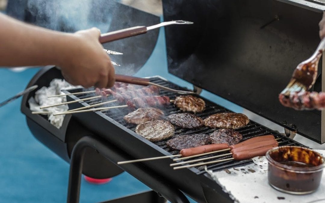 BBQing hamburgers and hotdogs on an outside patio