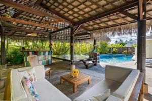 Covered stone patio with pool and seating