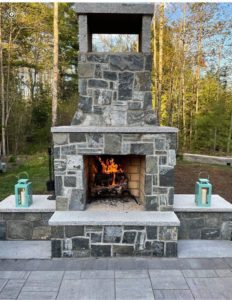Stone fireplace in Maine backyard 