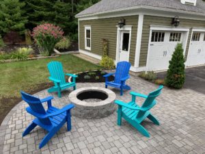 stone patio with landscaping and Adirondack chairs