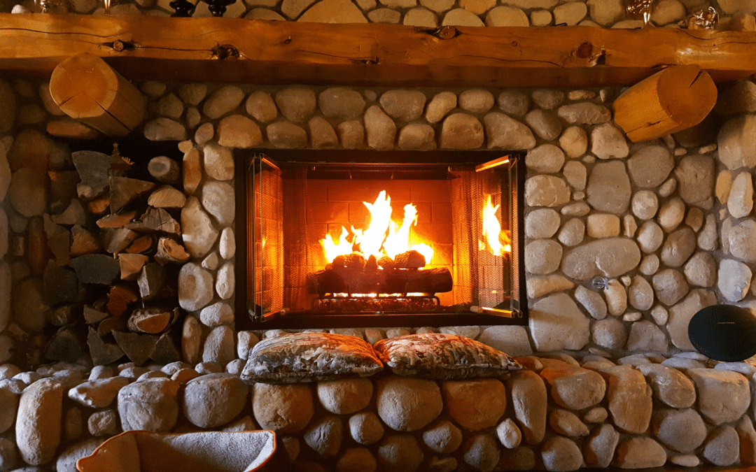 stone fireplace with a roaring warm fire and natural wood mantel