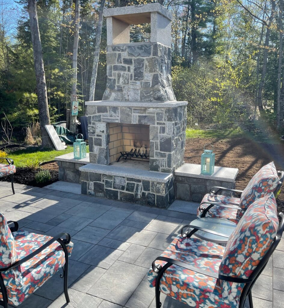 Natural stone outdoor fireplace with seating on patio