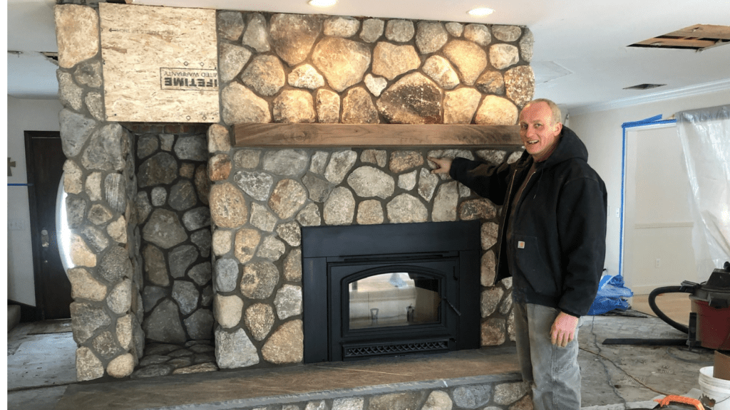 Rob of Stone Solutions Maine with stone veneer fireplace