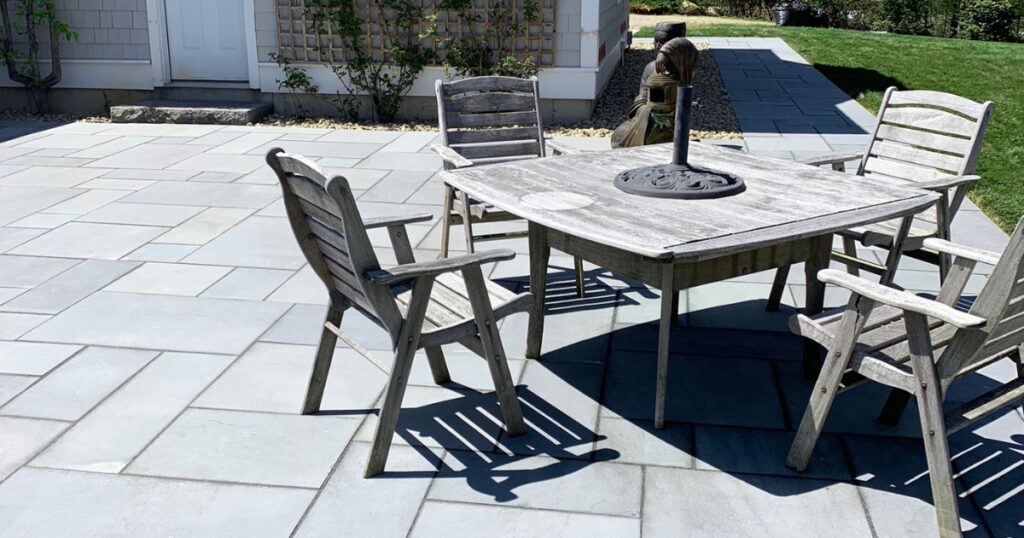 weathered-outdoor-dining-set-gray-stone-patio-pavers