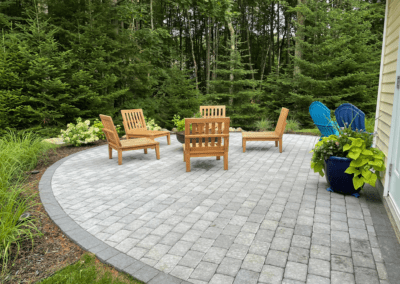 curved-paver-patio-teak-furniture-wooded-backyard-maine