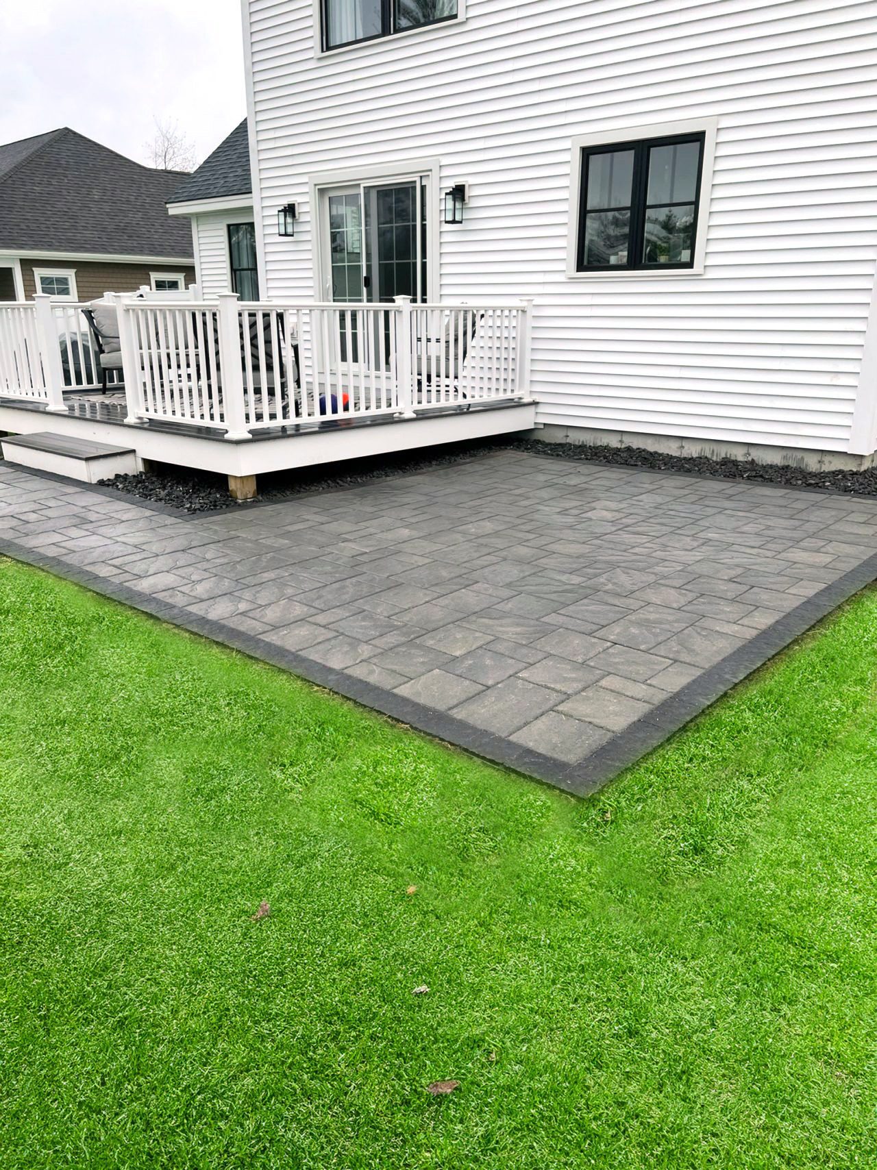 charcoal-concrete-paver-patio-with-dark-border-deck-maine