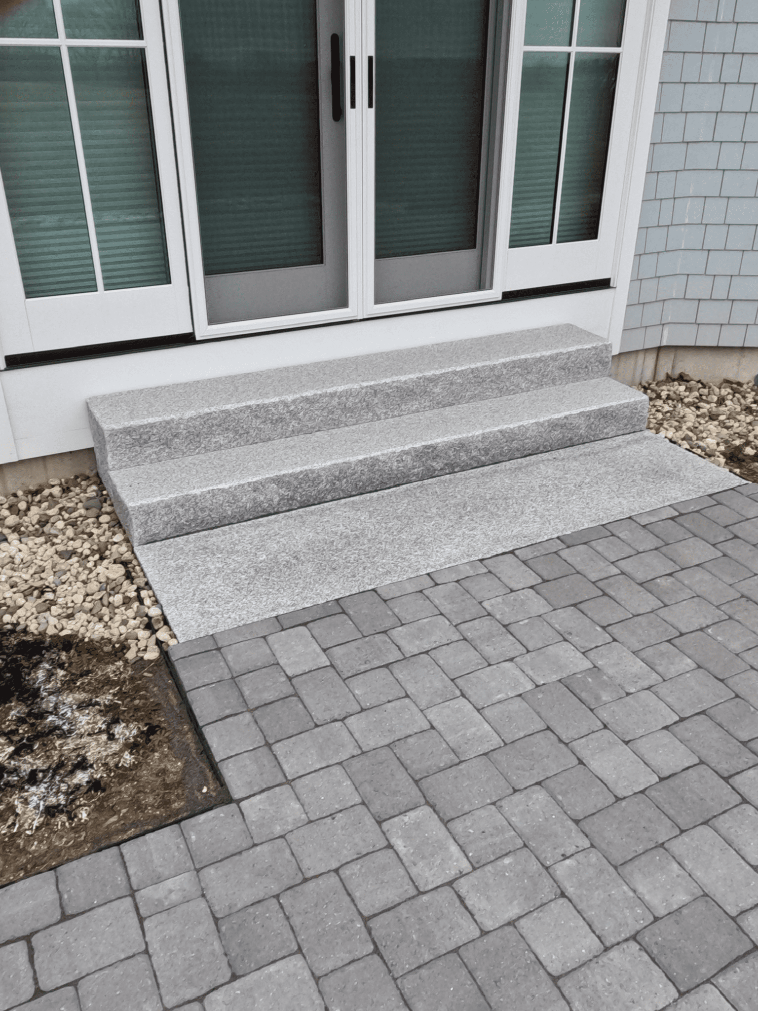 granite-steps-french-doors-cobblestone-paver-patio-coastal-maine