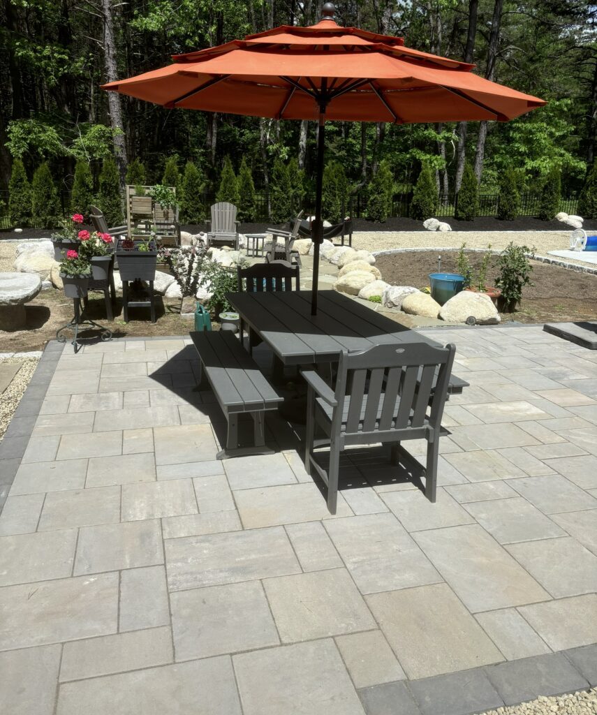 paver-patio-outdoor-dining-umbrella-boulder-landscaping-maine