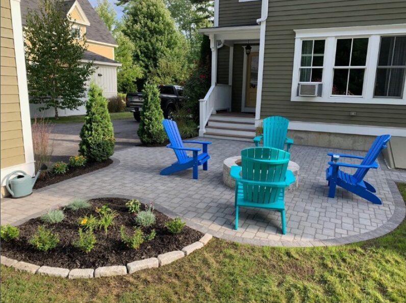 Front yard paver patio with a fire pit and Adirondack chairs, part of a landscaping refresh in Yarmouth, Maine